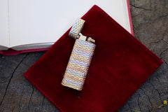 Cartier 18k tri-color gold lighter, overhead view with cap open on burgundy suede